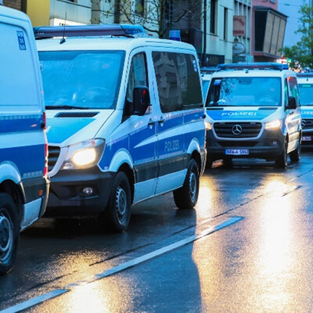 Mehrere Polizei-Autos stehen bei einer Razzia hintereinander.