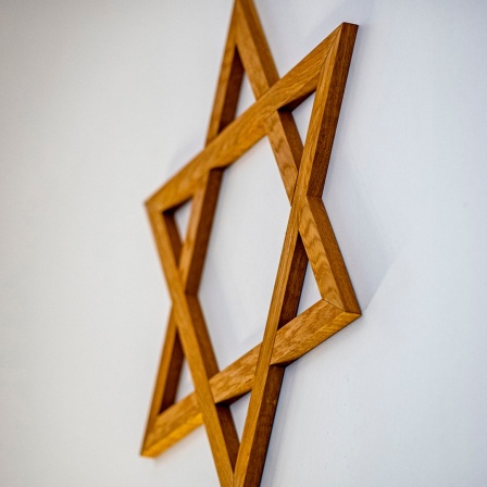Ein Davidstern aus Holz hängt an der Wand einer Synagoge.