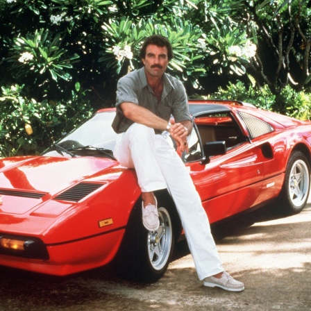 Tom Selleck als Thomas Magnum mit seinem roten Ferrari in einer Szene der TV-Serie "Magnum" (Aufnahme von 1985)