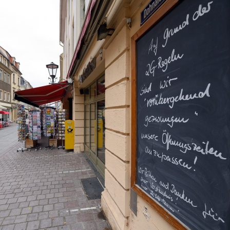 Auf einem Schild wird vor einem Cafe auf die vorrübergehende Schließung wegen der 2G-Regel hingewiesen.