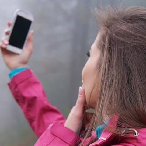 Eine Frau sucht mit ihrem Handy nach einem Signal