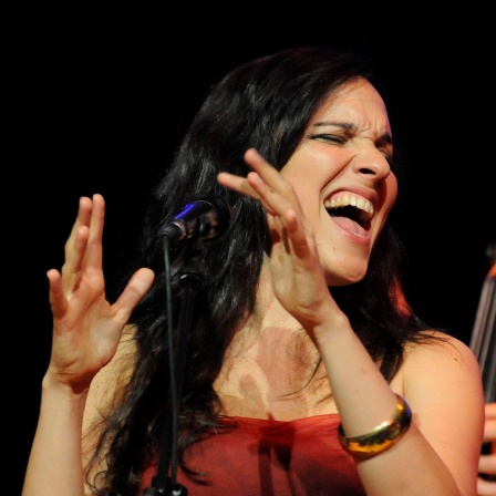 Sängerin Simin Tander singt und klatscht.
