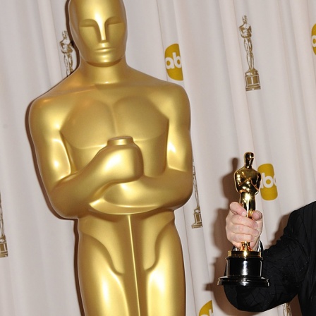 Randy Newman hält seinen Oscar-Award in der Hand.