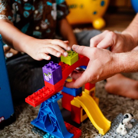 Pflegekind und Pflegevater spielen zusammen (Bild: picture alliance/dpa/Uwe Anspach)