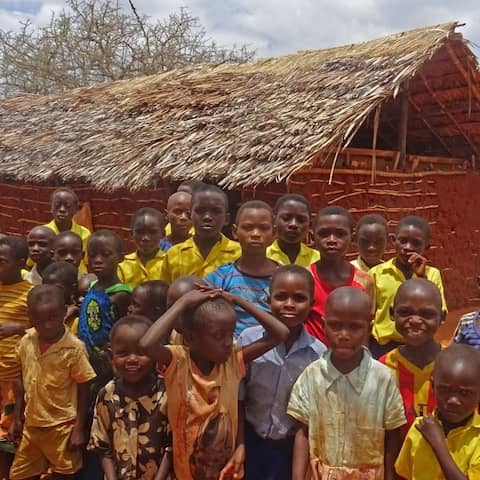Afrikanische Kinder vor ihrer provisorischen Schule, eine Lehmhütte