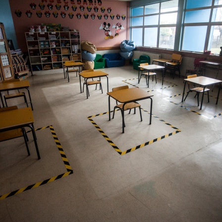 Ein Klassenzimmer mit markierten Stellen und Einzelplätzen zur Einhaltung der sozialen Distanz während Corona