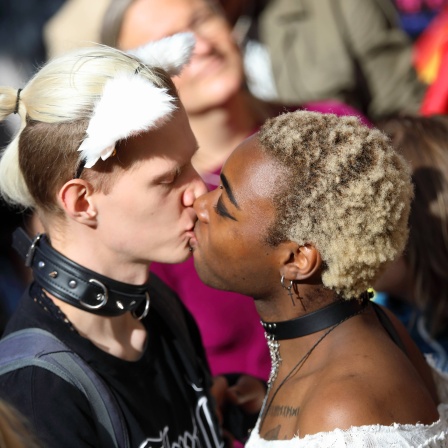 Ein nonbinäres Paar küsst sich am Christopher Street Day 2024 in Eisenach