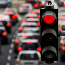 Straße voller Autos mit roten Rücklichtern unter roter Ampel