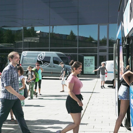 Alexander Schmidt und zwei Mädchen steigen in den Bus zum Kinderchor-Chorlager
