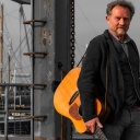 Musiker Otto Groote mit einer Gitarre am Hafen