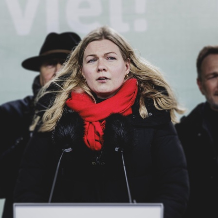 Theresa Schmidt, Vorsitzende des Bund Deutscher Landjugend, aufgenommen im Rahmen der Bauern-Proteste in Berlin im Januar 2024. Sie steht vor einem Mikrofon und trägt eine schwarze Jacke und einen roten Schal.