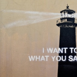 Blick auf ein Banksy-Gemälde an einer Hauswand, das einen Leuchtturm zeigt.