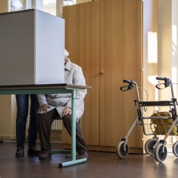 Ein ältere Wählerin mit Begleitung gibt ihre Stimme für die Bundestagswahl ab in einem Wahllokal in Potsdam