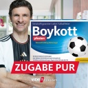 Satirische Fotomontage: Thomas Müller im DFB-Trikot lacht in die Kamera, daneben die Packung des fiktiven Medikaments "Boykott Pfosten"