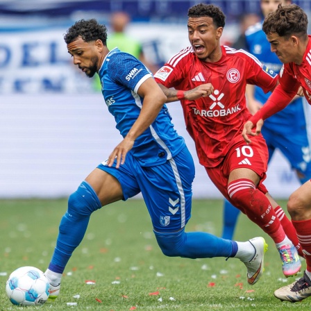 Magdeburgs Xavier Amaechi kämpft gegen Myron van Brederode und Giovanni Haag von Fortuna Düsseldorf um den Ball