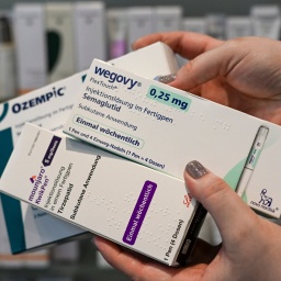 Spritzen der Marken &#034;Wegovy&#034;, &#034;Ozempic&#034; und &#034;Mounjaro&#034; werden in einer Apotheke verkauft - eine Angestellte hält die drei Packungen mit ihren beiden Händen.
