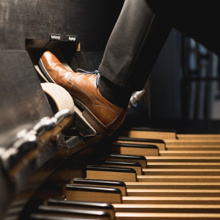 Mann spielt Orgel mit Pedal