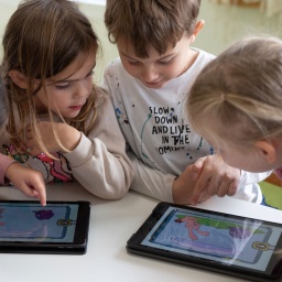 Vier Kinder arbeiten mit einem Tablet.