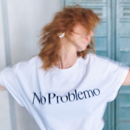 Mit ausgebreiteten Armen und einem T-shirt mit der Aufschrift No Problemo blickt Franziska Knost zur Seite.