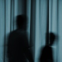 Schatten von zwei Personen hinter einem Vorhang.