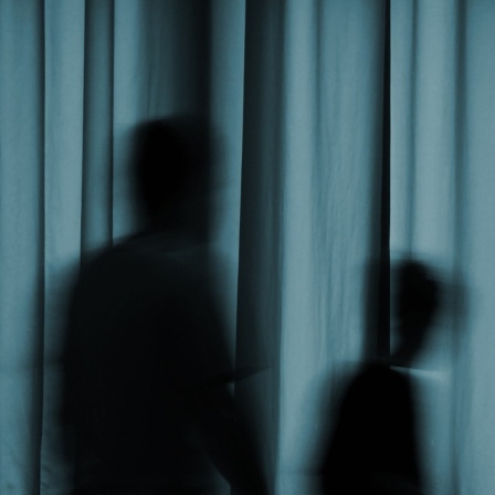 Schatten von zwei Personen hinter einem Vorhang.