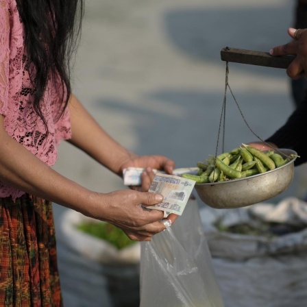 Eine Frau kauft Chili auf dem lokalen Markt