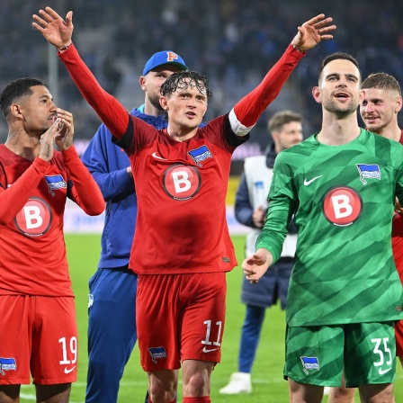 Die Hertha-Spieler Jeremy Dudziak, Fabian Reese, Marius Gersbeck und Toni Leistner feiern mit den Fans nach dem Auswärtssieg in Paderborn (Bild: IMAGO / Ulrich Hufnagel)