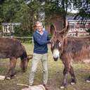 Dr. Rainer Hagencord auf einer Wiese zwischen zwei Eseln