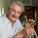 Der Trompeter Ludwig Güttler sitzt im Arbeitszimmer in seinem Haus und hält eine Trompete in der Hand. 