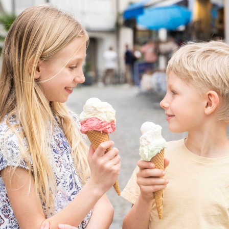 Lächelnde Geschwister mit Eis in der Hand