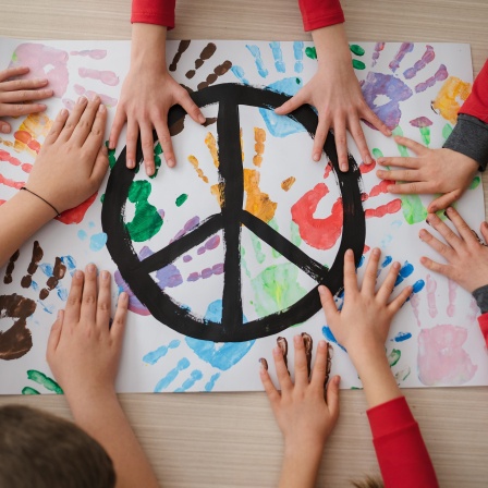 Eine Gruppe Kinder malt ein Bild mit dem Friedenssymbol