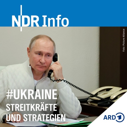Russlands Präsident Vladimir Putin am Telefon. Hinter ihm zwei weiße ältere Telefone. 