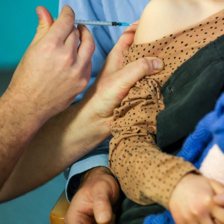Ein Kinderarzt impft ein 7-jähriges Mädchen gegen das Covid19-Virus.
