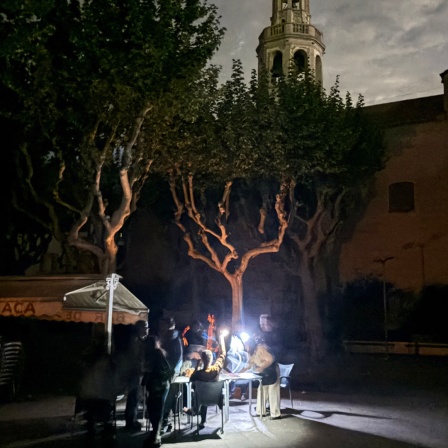 Auf der Placa de l'Ajuntament sitzen die Gäste eines Straßencafés in der Kleinstadt Premià de Mar bei Barcelona an der Kirche "San Cristòfol" bei einem Stromausfall im Licht von Taschenlampen und trinken lauwarmes Bier.