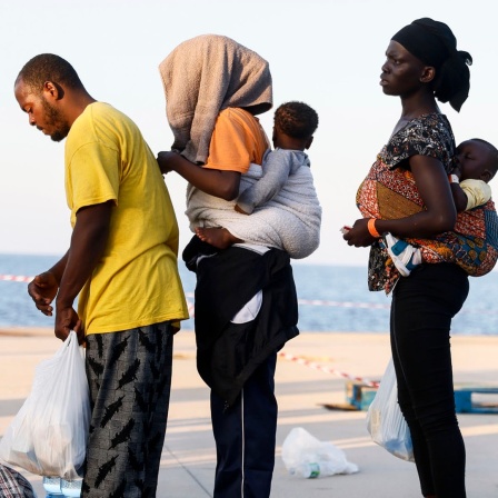 Menschen stehen auf der Insel Lampedusa in einer Reihe.