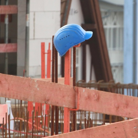 Helm steckt auf Zaun auf einer Baustelle
