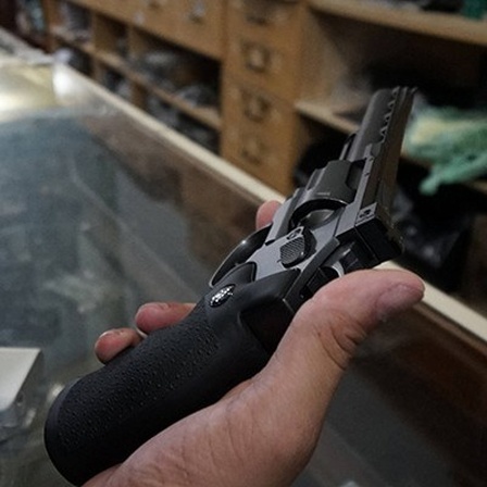 In einem Waffengeschäft in Brasilien hält jemand eine Kleinwaffe in der Hand; es sind Hand und Waffe zu sehen sowie der Laden (21.01.2019)