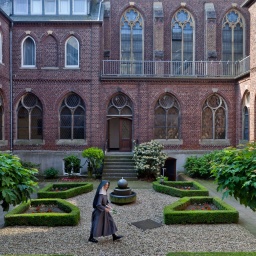 Das Beitragsbild des Dok 5 Feature "Ora et labora - Wirtschaftsunternehmen Kloster", zeigt den Innenhof der Abtei Mariendonk. In der Mitte der Außenanlage ist eine Nonne zu sehen