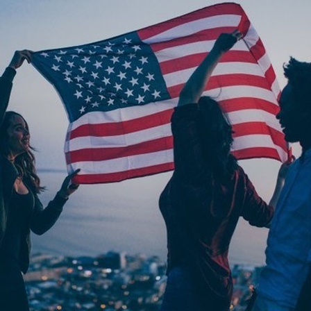 Junge Menschen halten die US-Flagge hoch.