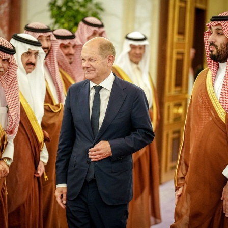 Bundeskanzler Olaf Scholz (M, SPD) wird vom Kronprinzen des Königreichs Saudi-Arabien Mohammed bin Salman al-Saud (r) und einer Delegation im Al-Salam-Palast empfangen. 