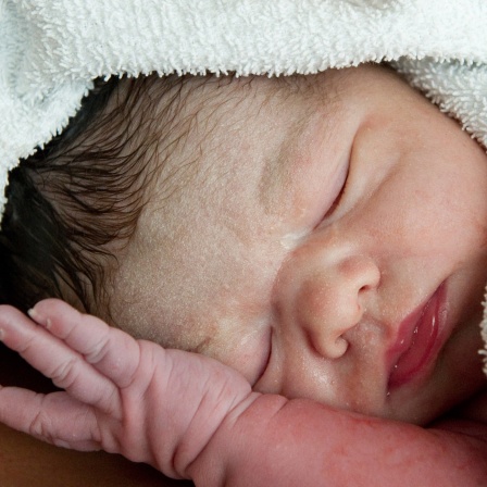 Neugeborenes in ein Handtuch gewickelt