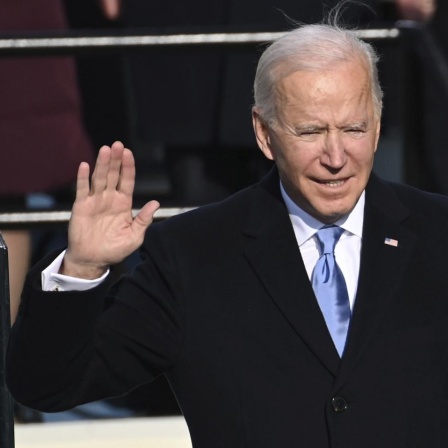 Joe Biden wird als US-Präsident vereidigt und schwört auf die Bibel, rechts von ihm steht seine Ehefrau. 