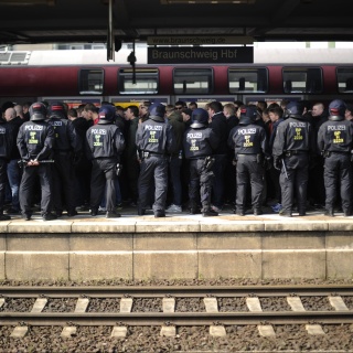 Polizeibeamte stehen auf dem Hauptbahnhof in Braunschweig (Niedersachsen) am Bahnsteig, um 700 ankommende Ultras und Hooligans zu empfangen.
