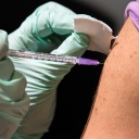 Ein Mann lässt sich bei gegen Covid-19 in den Oberarm impfen.