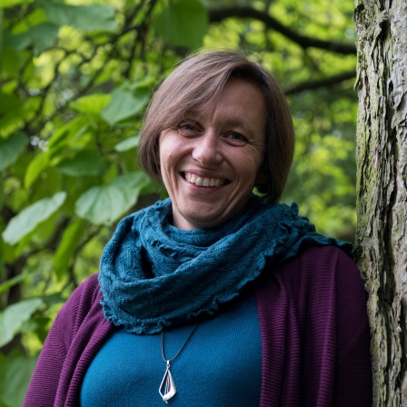 eine Frau lehnt an einem Baum