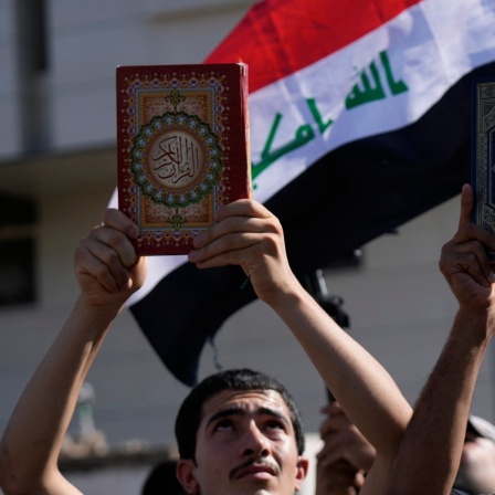 Anhänger des schiitischen Geistlichen Muqtada al-Sadr halten den Koran, das heilige Buch der Muslime, während einer Demonstration vor der schwedischen Botschaft in Reaktion auf die Koranverbrennung in Schweden hoch. 