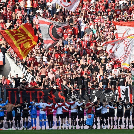 Union-Spieler feiern mit den Fans nach dem Sieg in Köln