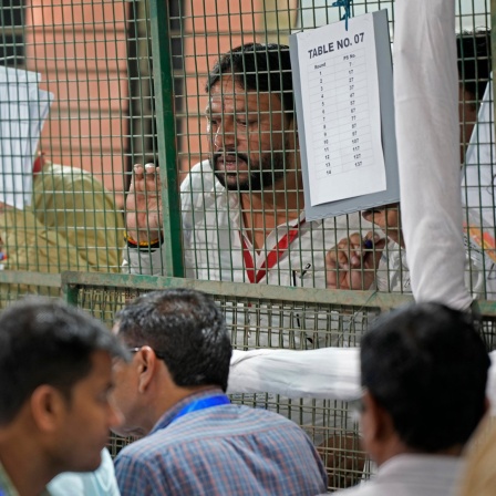 Wahlhelfer der politischen Parteien beobachten die Auszählung der Stimmen in einem Auszählungszentrum in Neu-Delhi.