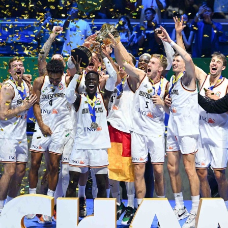Die deutsche Basketball-Nationalmannschaft feiert mit der Trophäe den WM-Titel bei der Siegerehrung.