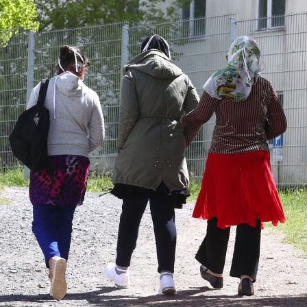 Drei Frauen gehen auf dem Gelände der Erstaufnahmeeinrichtung des Landes Thüringen spazieren.